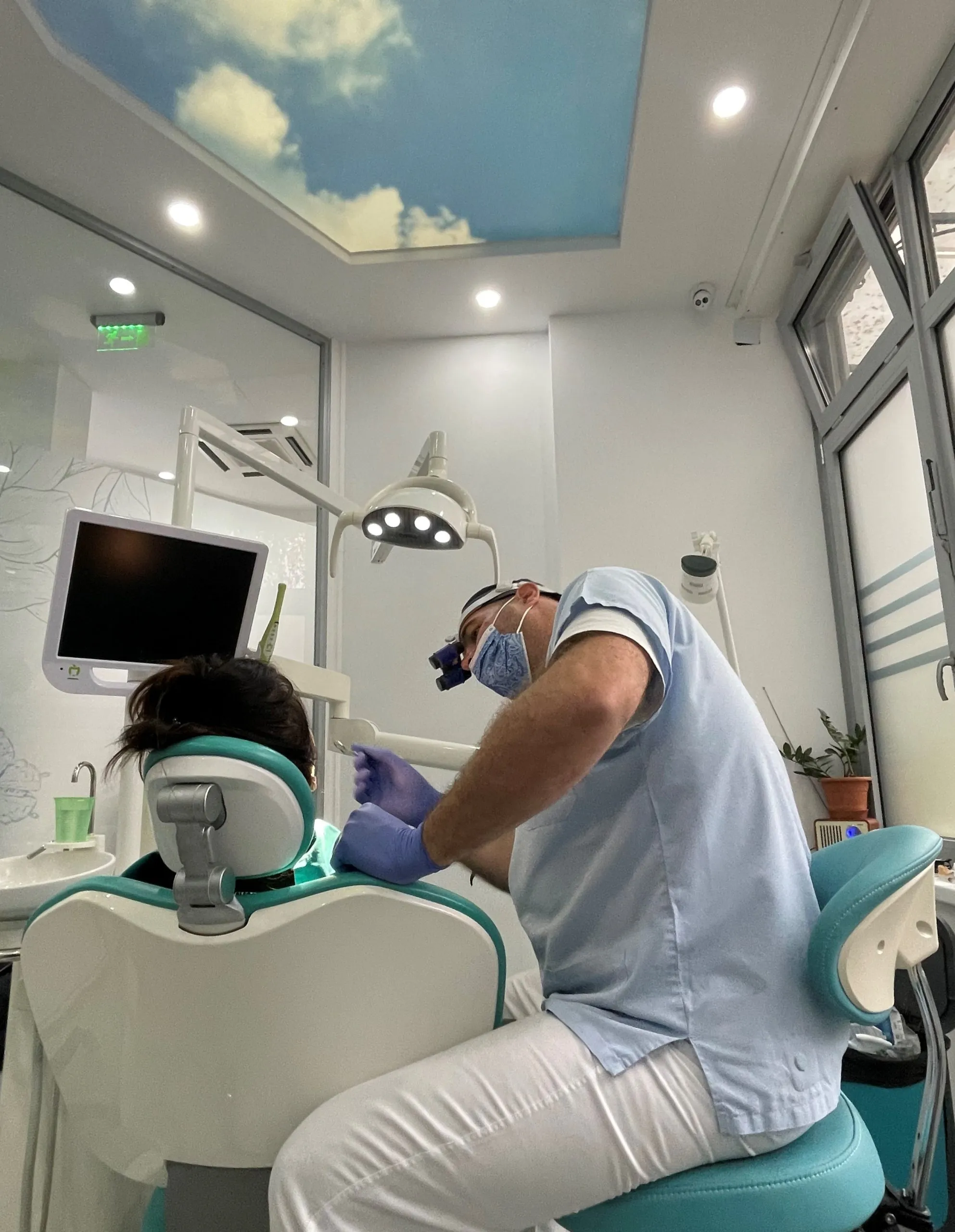 Dr Miloš Erić examining a patient, wearing dental loupes